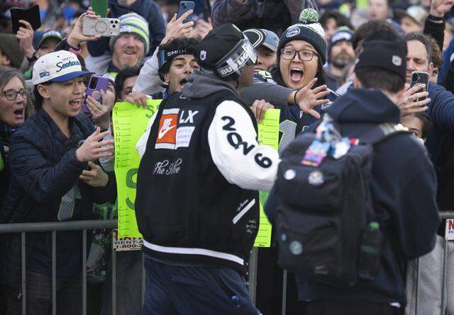 Seahawks wide receiver Tory Horton walks along the Super Bowl parade route as fans react on Wednesday, Feb. 11, 2026, in downtown Seattle.